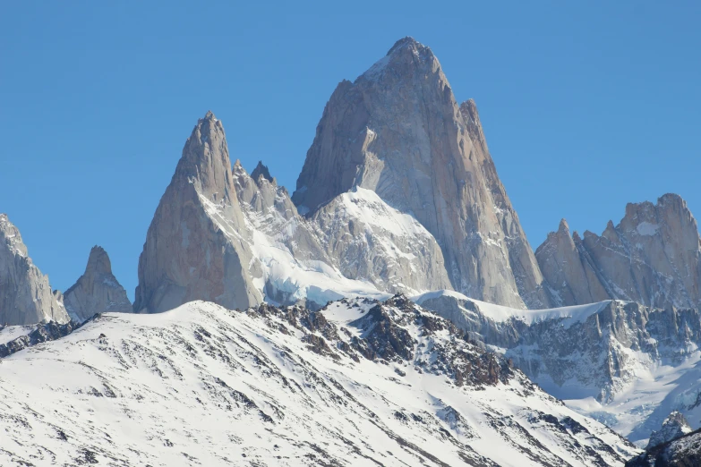 a group of mountains rise above some snow