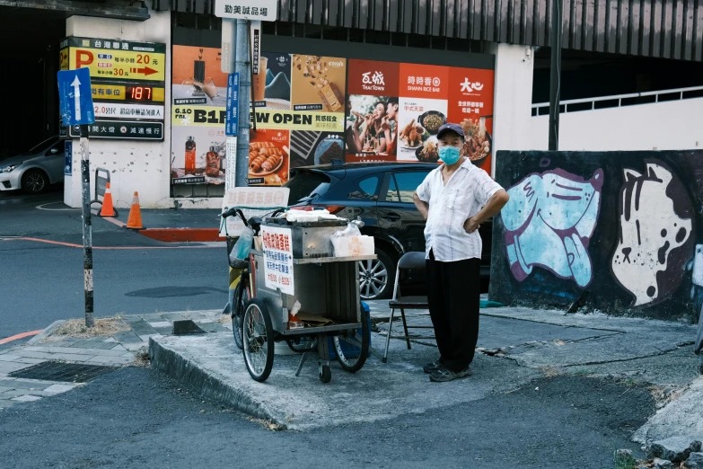 a man is standing on a city street corner with a cart