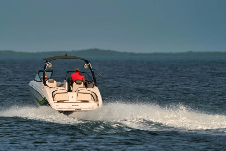 a man driving his speedboat across the ocean