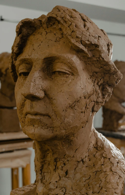 a statue of a woman in dirt, next to other sculptures