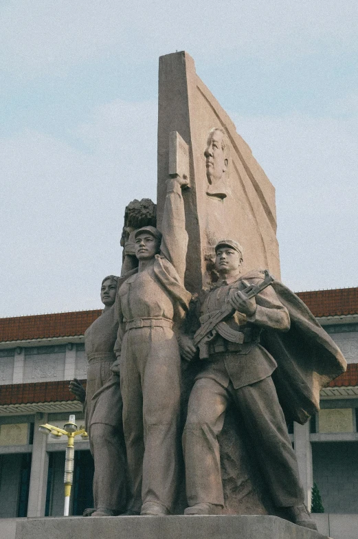 a statue sitting outside of a building with three men around it