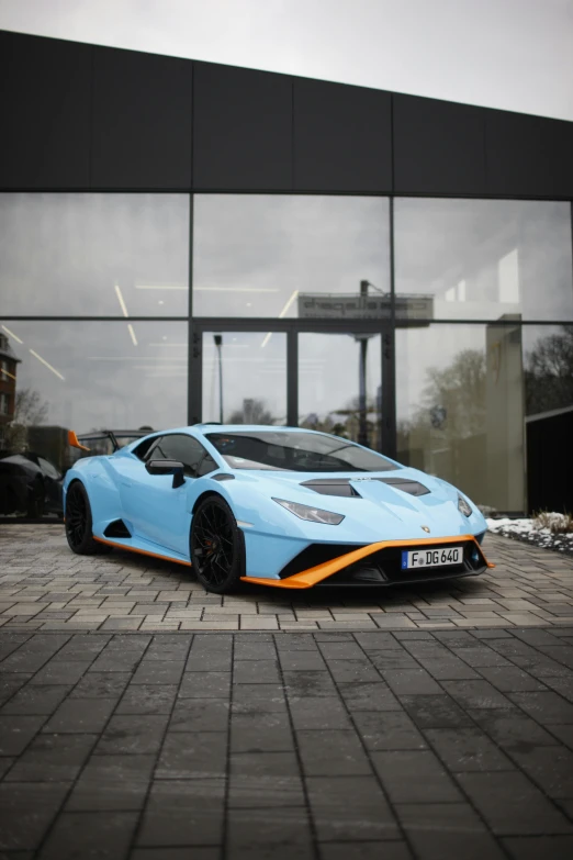 a light blue sports car parked in front of a building