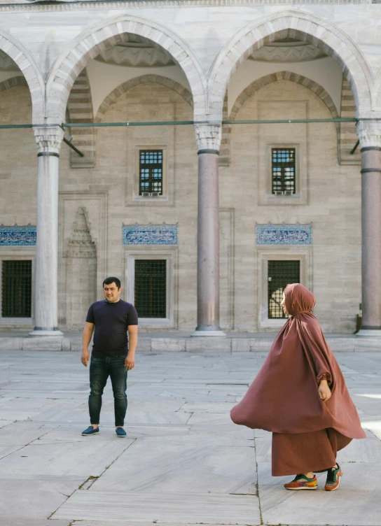 a man standing next to a woman and two arches