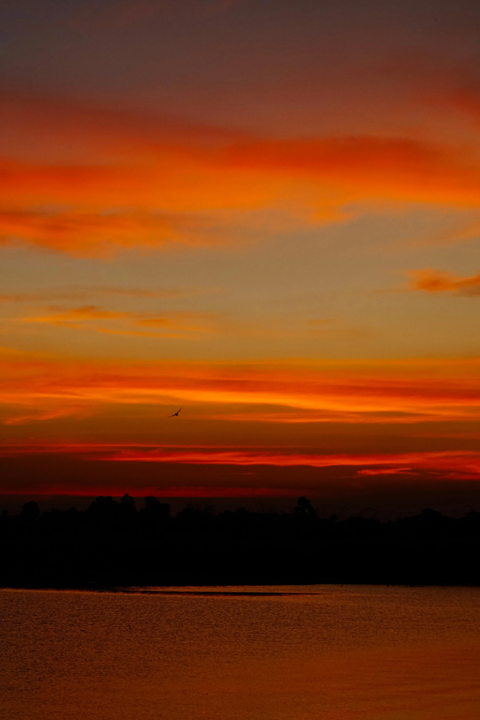 a red sunset with the sun on top of a mountain