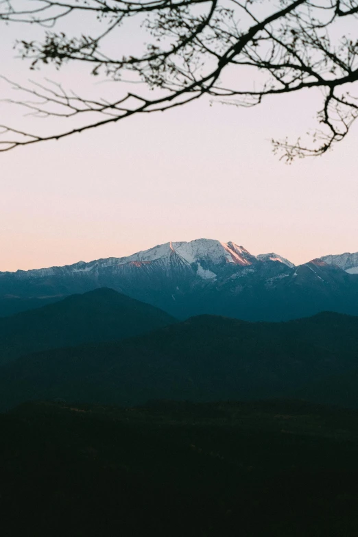 a mountain view from a distance of some snow capped mountains