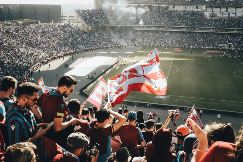 some fans on a crowded stadium watching a soccer match