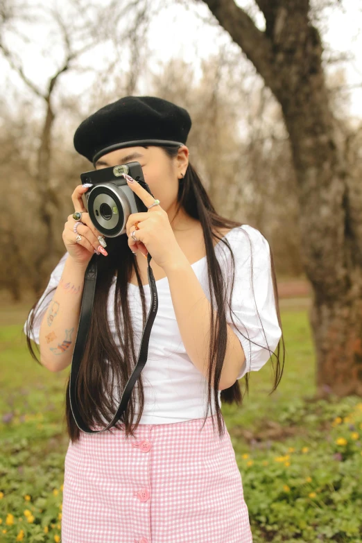 a girl with a hat holding a camera