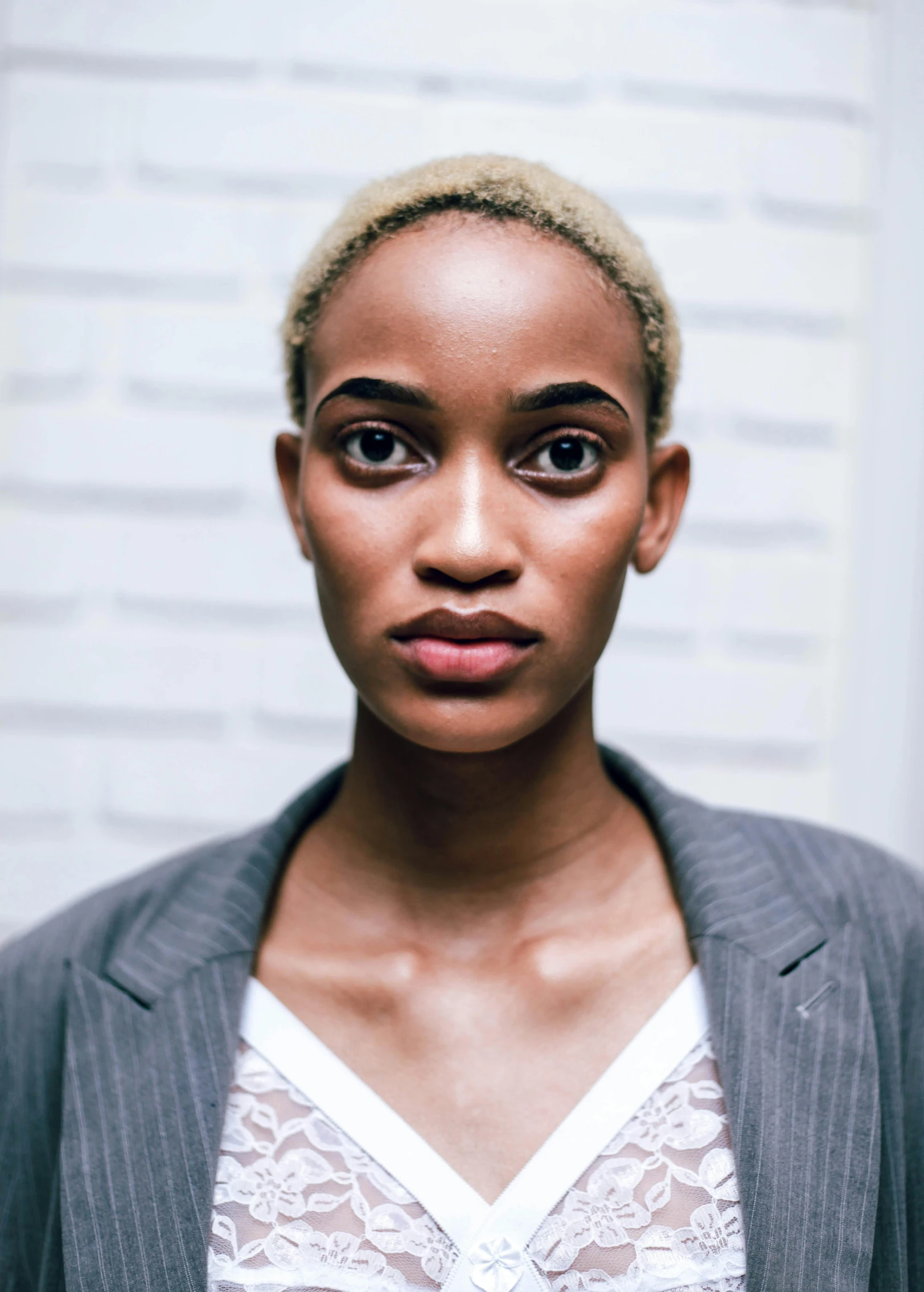 a woman with an open  top and grey blazer