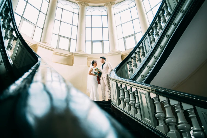 a couple on the escalator by a circular window