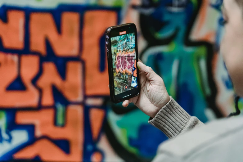 a person with their cell phone looking at the wall