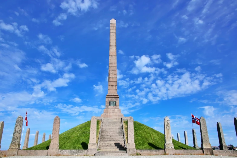 monument in a field that is on a hill with flags