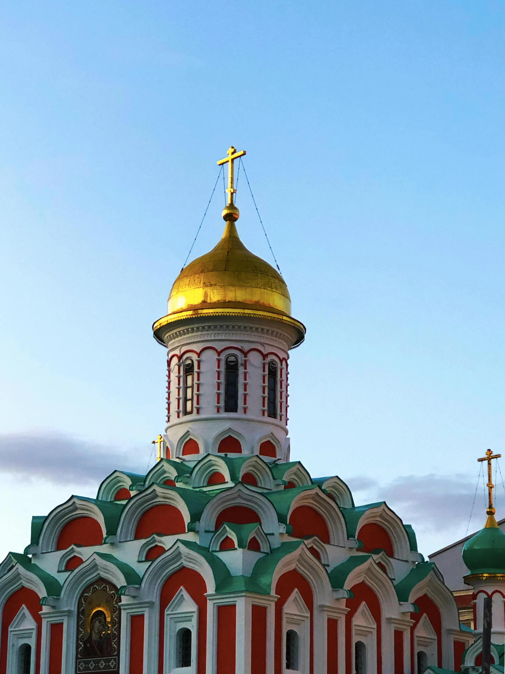 a large red and white church building with gold dome