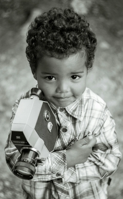 a small boy holds a toy car in his hands