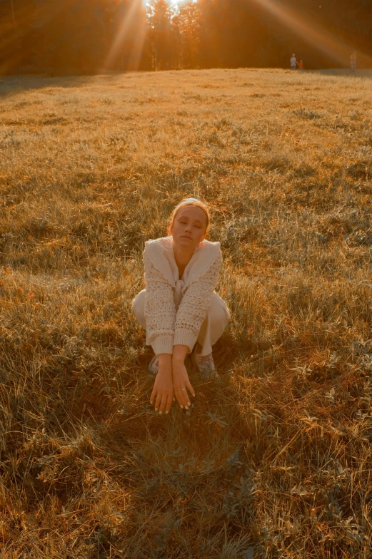a woman that is kneeling down in the grass