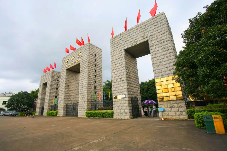 a group of stone columns that have red flags on top of them