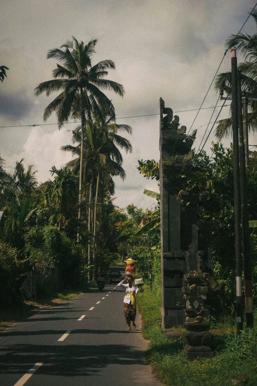 two people riding down a rural road near a wooded area