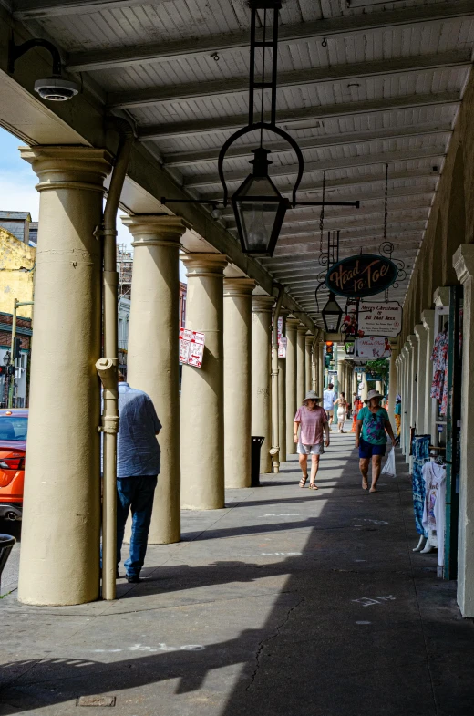 people walking on the sidewalk underneath an awning