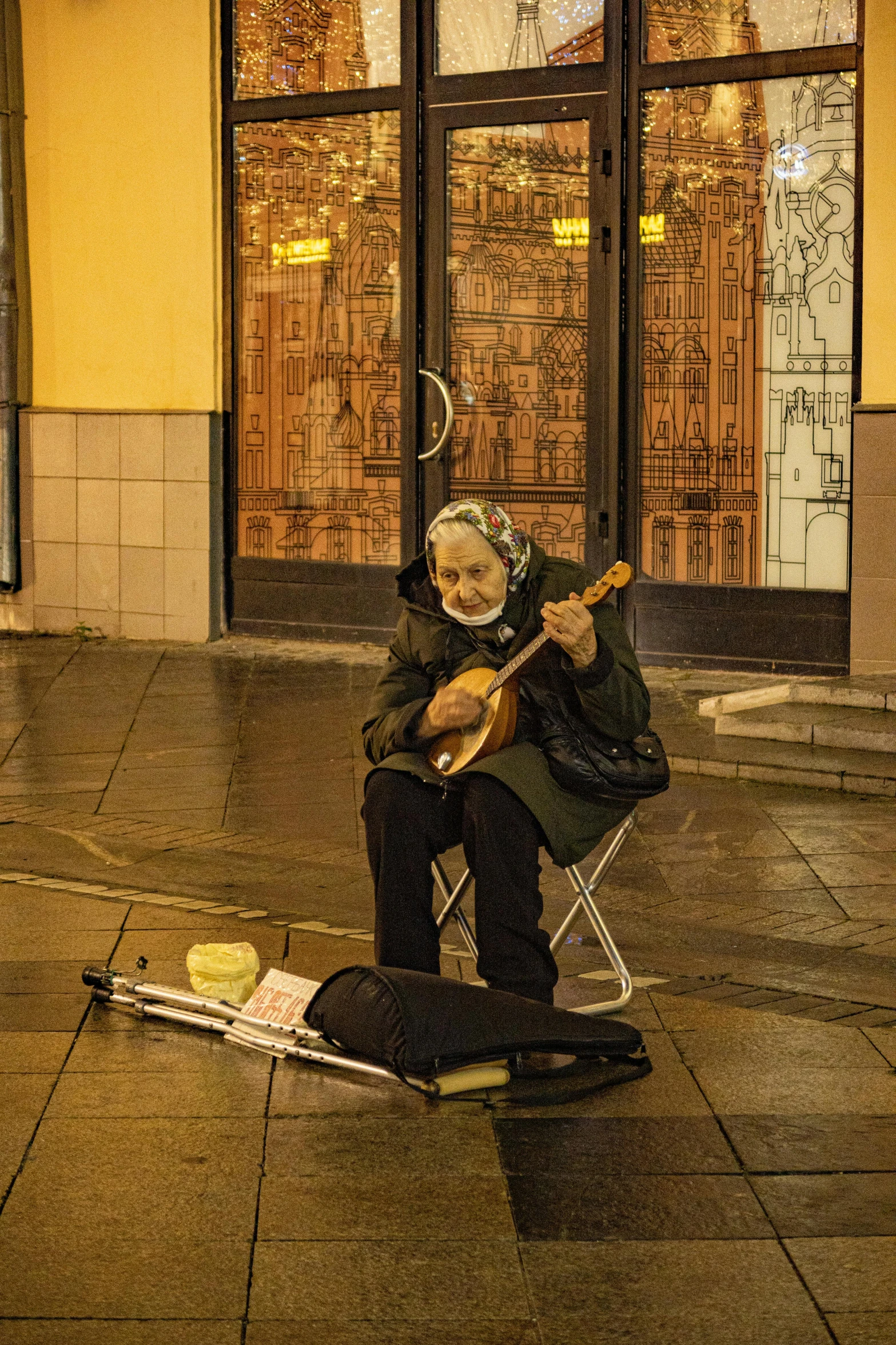 the woman is sitting down playing the guitar