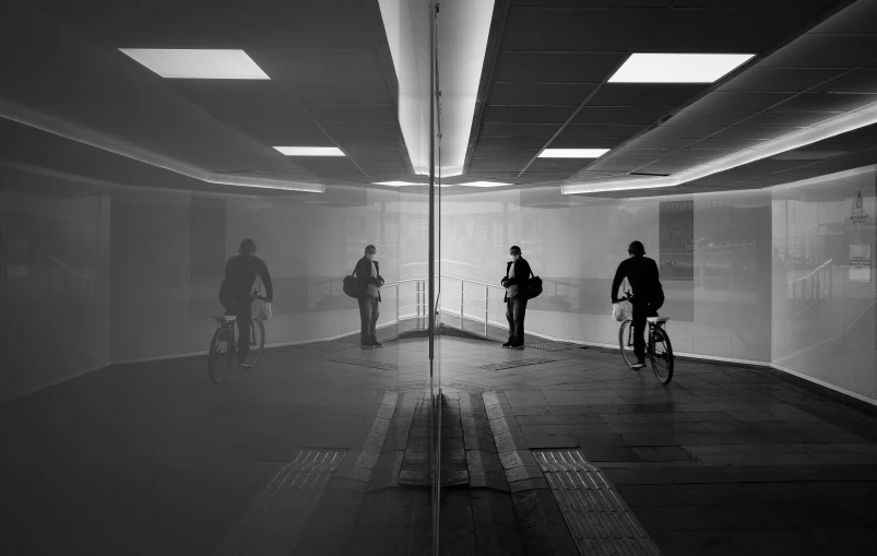 a couple of people are riding bicycles in a very large building