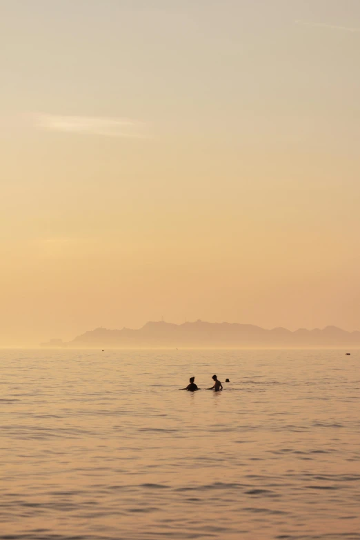 two people in water with airplane flying low to them