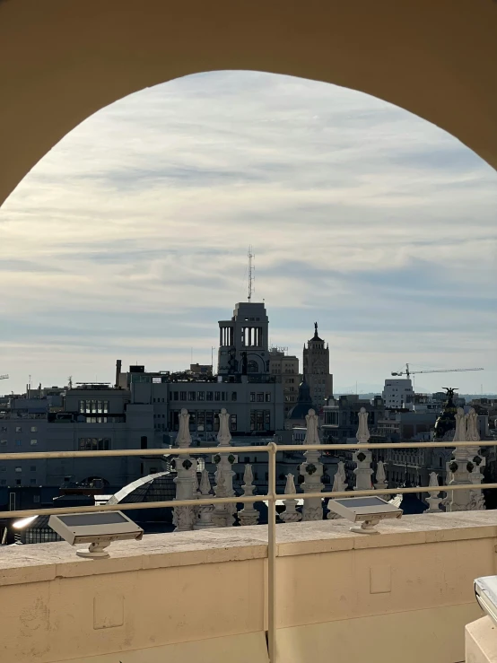 a balcony view of a city with an arch opening