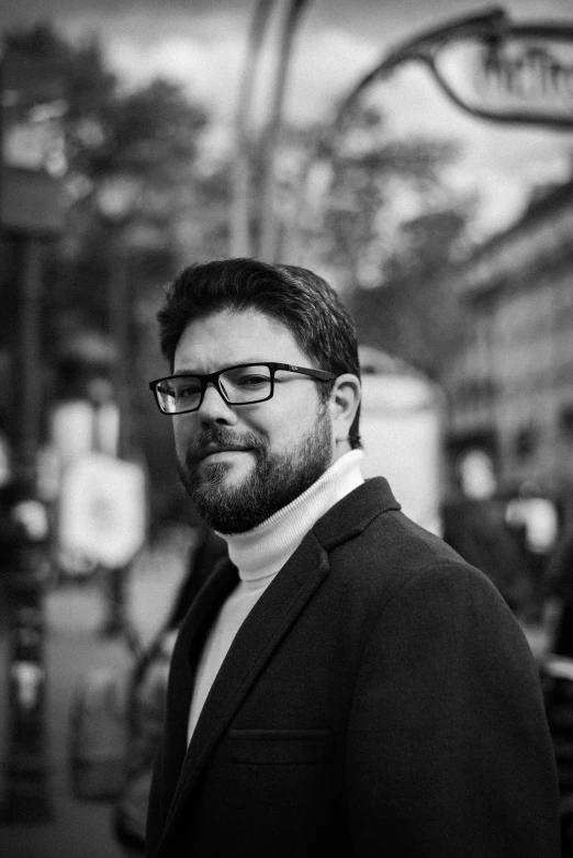 a man in glasses is standing in a subway