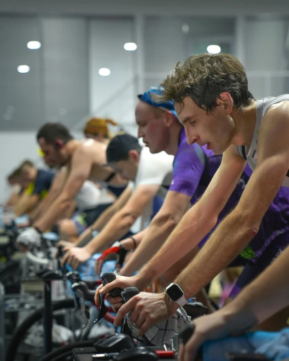 several men riding bikes in an indoor cycling club