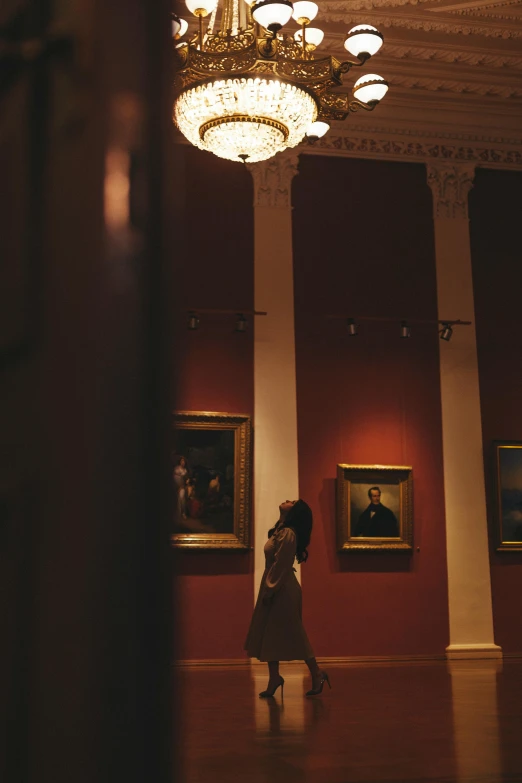 a woman in a room with paintings on the wall