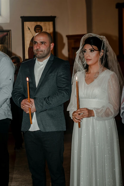 the bride is holding a candle with the groom