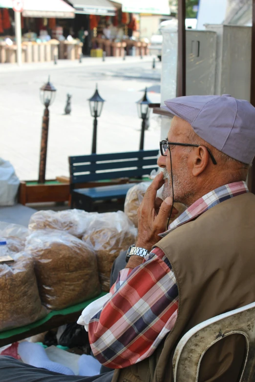 a man is sitting outside on a phone