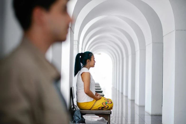 a woman sitting down in a long hallway