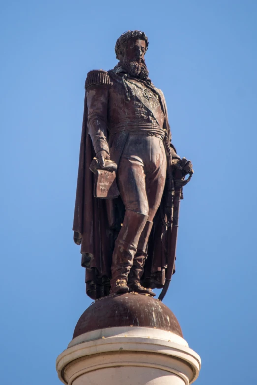 a statue of a man wearing a suit and holding a hammer is on top of a column