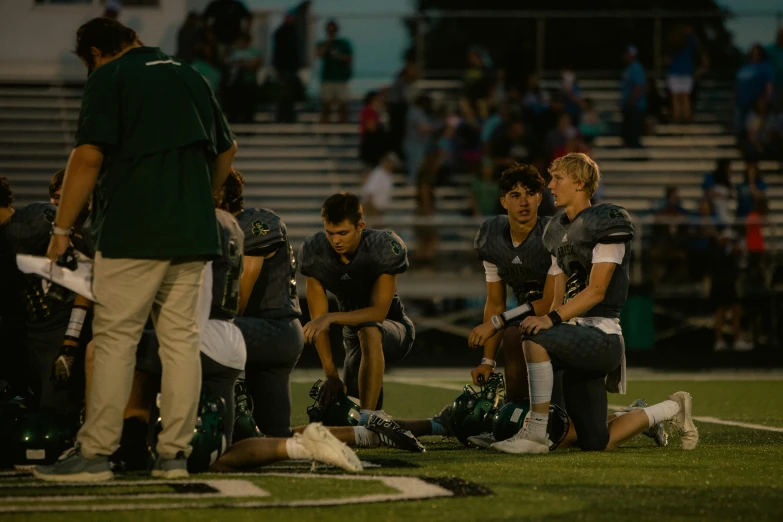 the players are sitting on the field during a football game