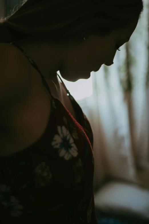 a woman standing in front of a window in front of a curtain