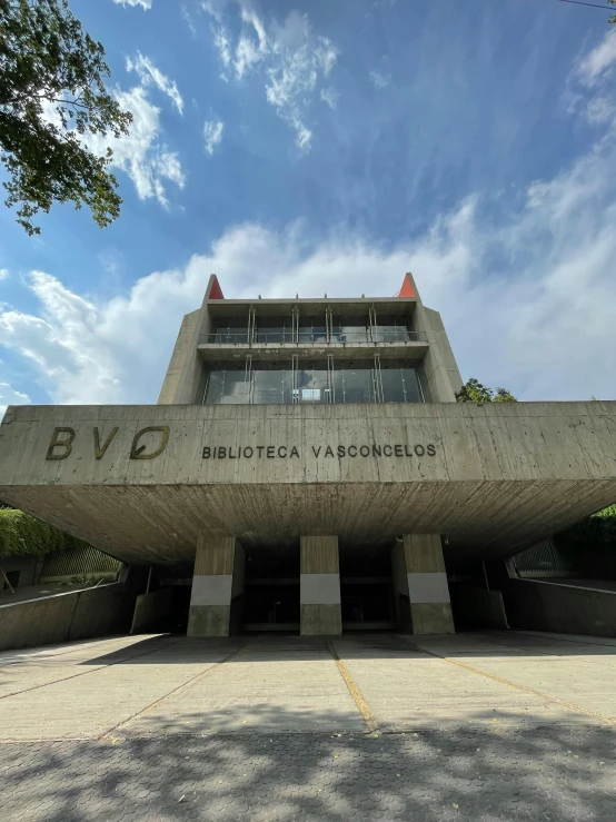 a building with a large, triangular design next to trees