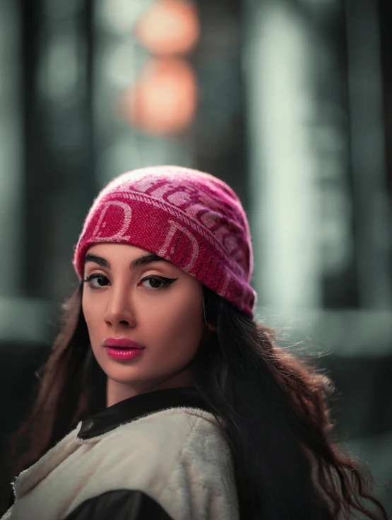 a woman with long brown hair wearing a pink hat