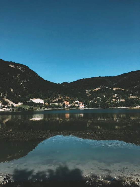 the water is crystal clear with some mountains in the background