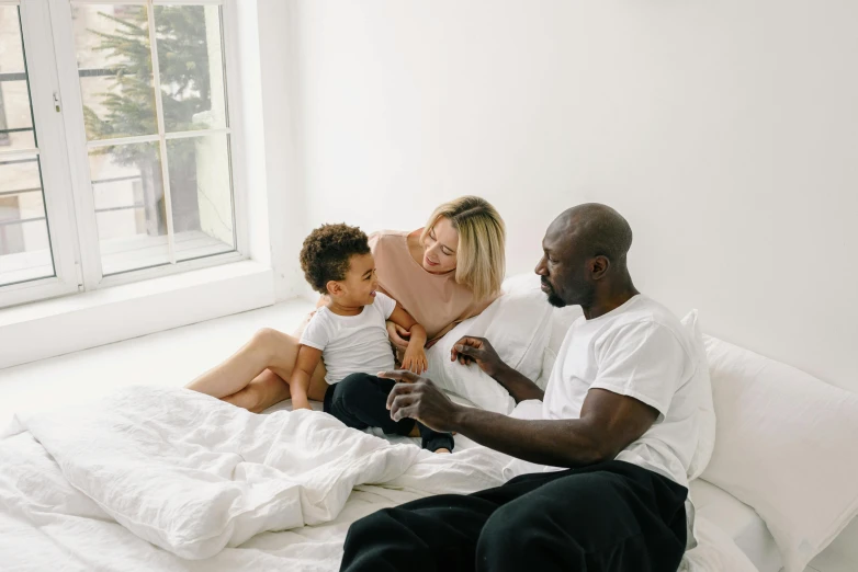 a woman with two children on a bed