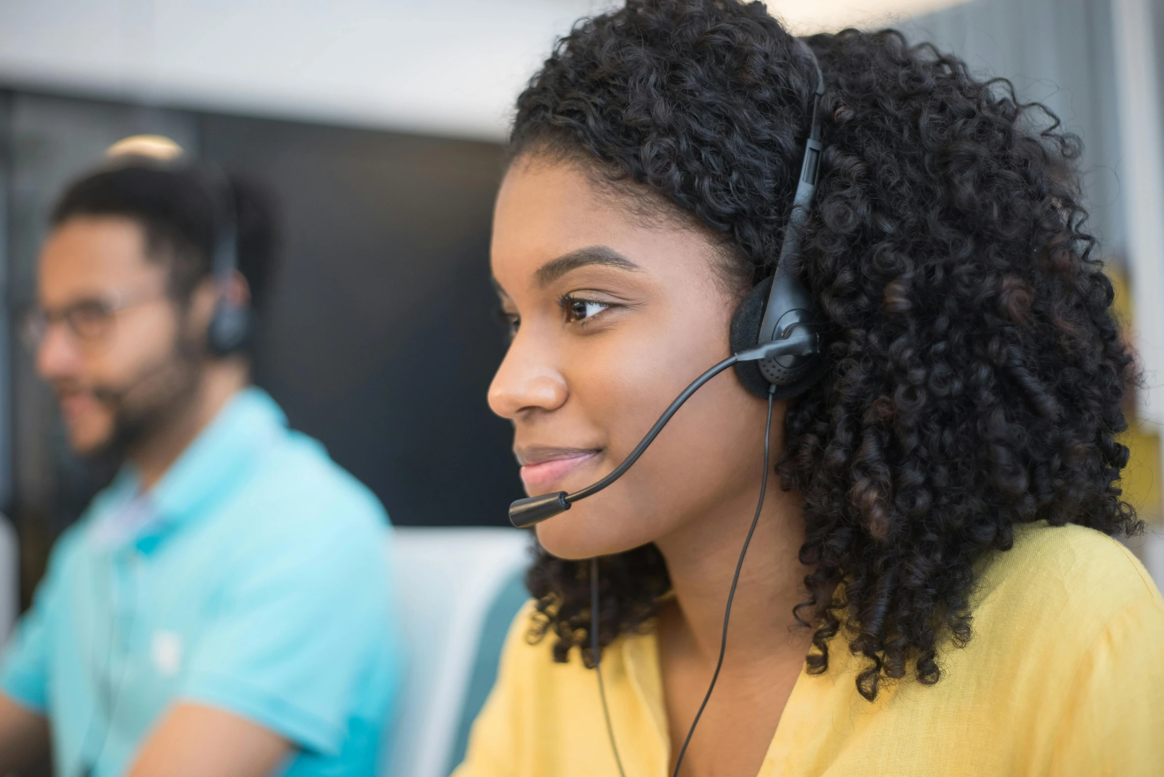 a young black woman using a headset in an office