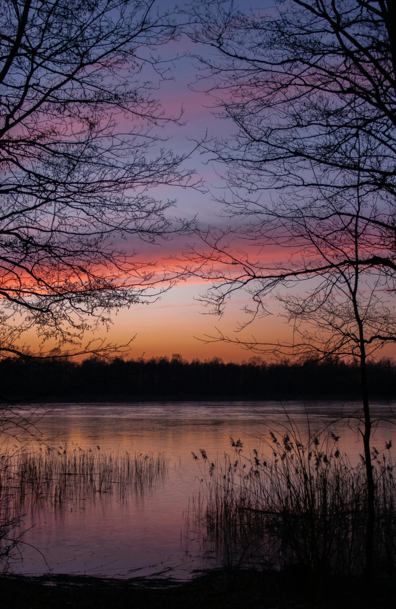 a large body of water at sunset with a small boat on the water