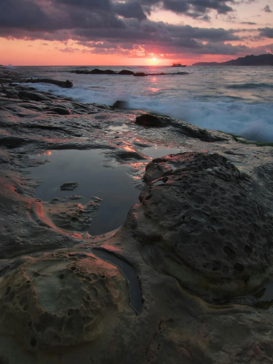 the sun is setting behind the clouds and reflecting in the water