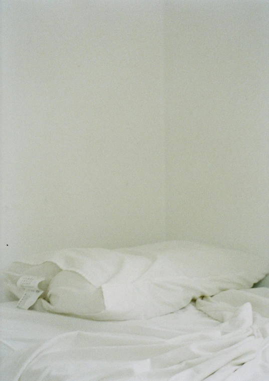 a bed with a white blanket and pillows