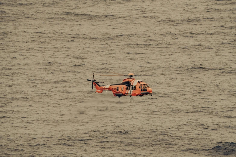 a red helicopter floating on top of a body of water