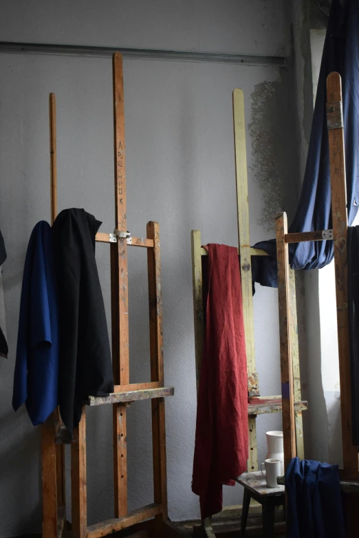a room with various chairs and clothing on the rack