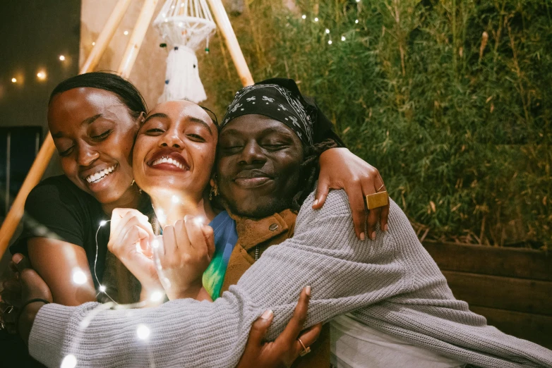 three women, one wearing a head scarf, are smiling and laughing