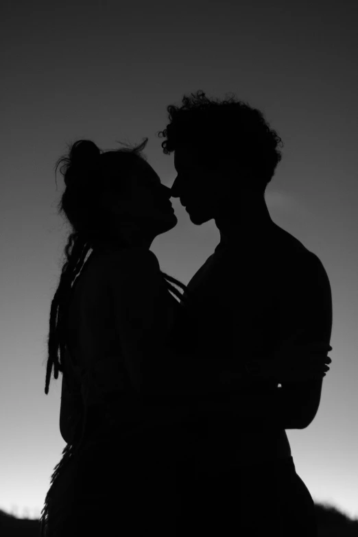 silhouette of two people kissing in the twilight
