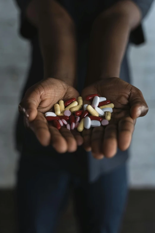 a person holding several pills in their hands