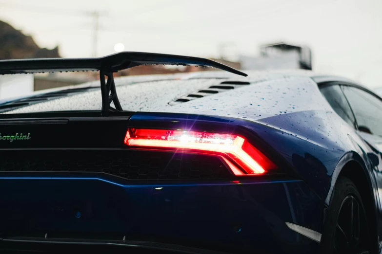 the back end of a sports car with rain on it