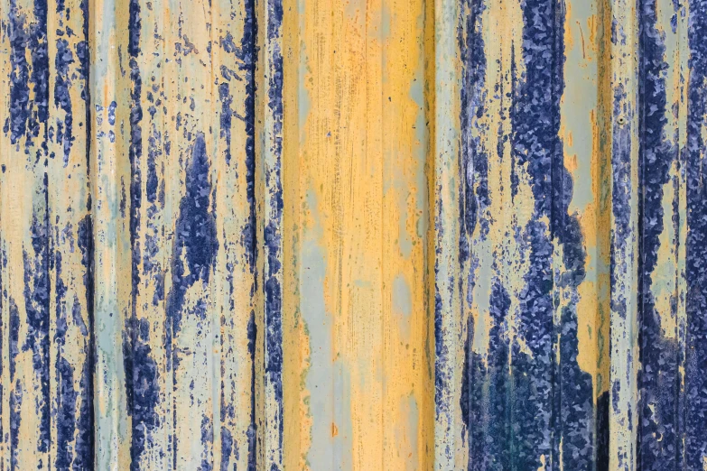 yellow and blue wallpaper that is peeling paint