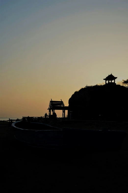 boat in silhouette near a pier at sunset